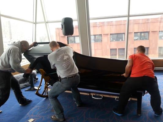 Three man move concert grand presented to NYU by Frank Sinatra