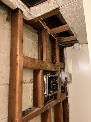 The existing service entrance panel and electrical meter were in a basement bathroom next to the shower.