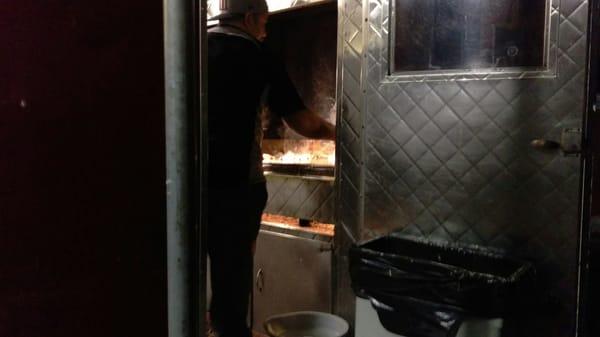 Kitchen action. After the meats are slow cooked in a smoker the final prep takes place on the grill.