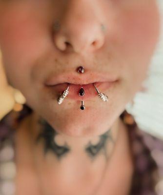 Three lip piercings and a philtrum piercing