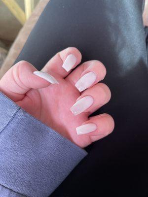 Long white nails in coffin shape. Iridescent butterfly glitter on middle and ringer finger.