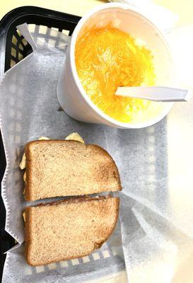 Smoked sausage sandwich and large bowl of cheese grits