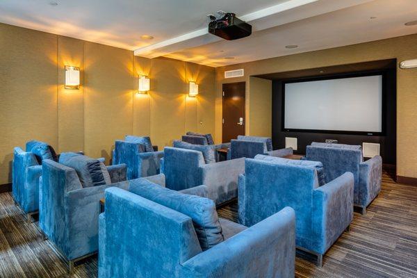 Media room for watching movies with large TV and comfortable seating.