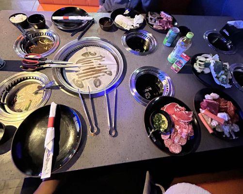 the table, the raw meat, the veggies, hot pot