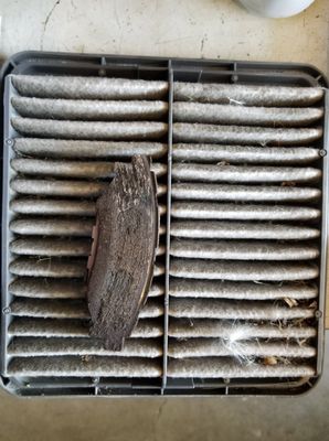 Horribly dirty air filter with brake pad that is worn to the metal shortly after inspection