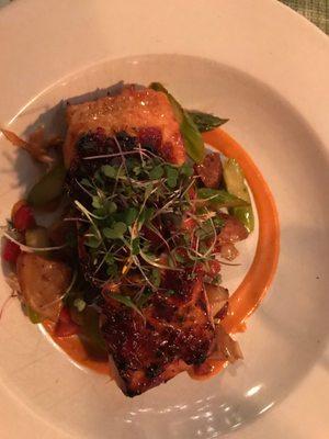 Salmon with a spicy jam glaze and sprouts of arugula.