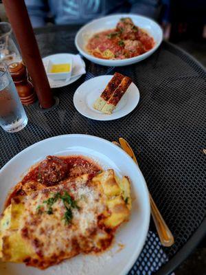 My baby-sized manicotti foreground,  delicious focaccia bread melted butter,  and the delicious spaghetti and meatballs!