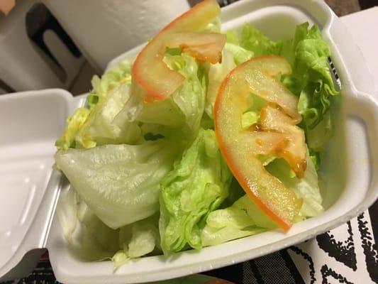 Side salad. Pile of iceberg with nothing but two paper thin slices of a quarter tomato.