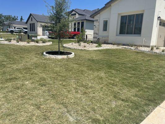 Installation of 6" boarder stone with washed river rock in the flower beds