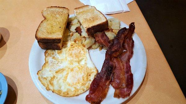 Bacon, eggs over medium, house potatoes and toast.