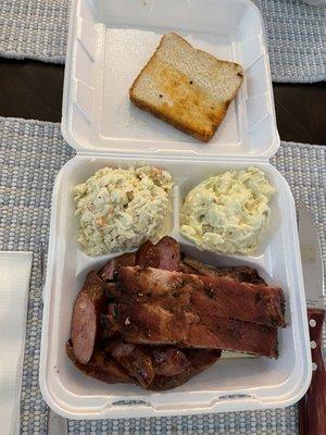 Tin Roof plate with sliced brisket, ribs, and sausage with coleslaw and potato salad