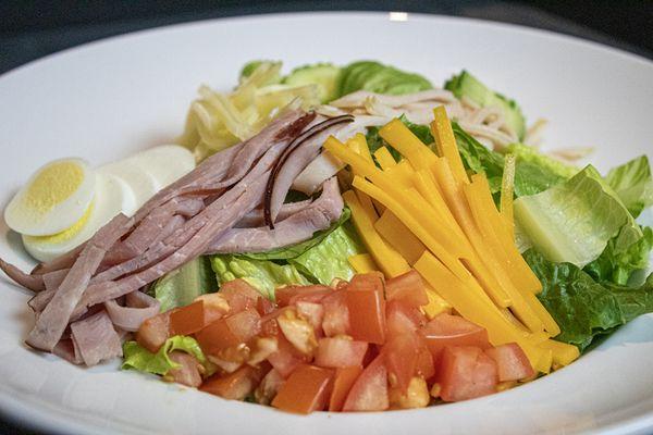 Chef Salad with romaine, Swiss cheese, cheddar, ham, turkey, egg, and tomato. Have it your way.