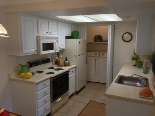 Upgraded Kitchen. White Painted Cabinets and a Microwave installed above the Stove.