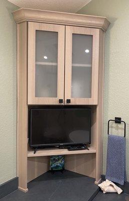 Frosted glass in bathroom vanity's corner tower cabinet.