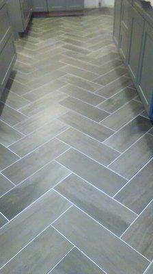 Installation of herringbone pattern ceramic tile.