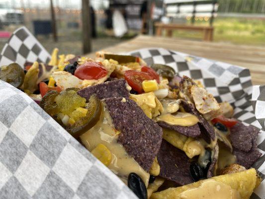 Trailside Nachos: Tortilla chips, house made cheese sauce, beans, corn, onion, tomato, guacamole, sour cream.