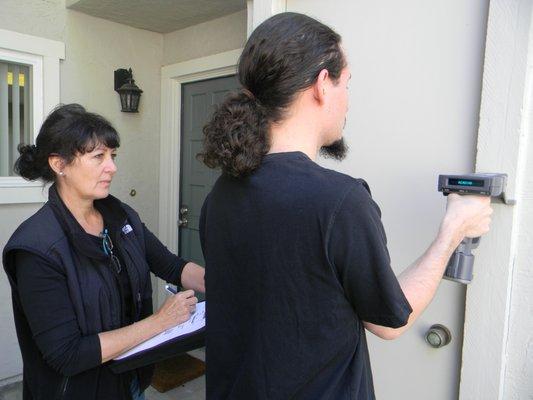 Two person team performing inspection, one using XRF Instrument, one charting testing locations.