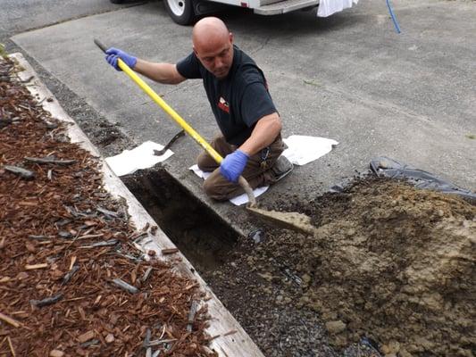 Jon working on a water line leak outside in a driveway