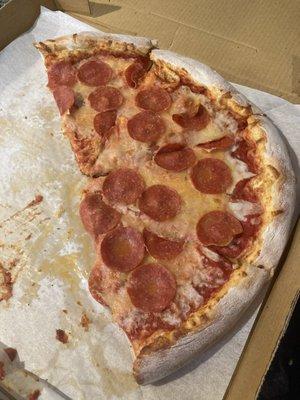 Large pepperoni pizza with half of it gone