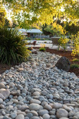 Large dry creek with lush estate landscaping