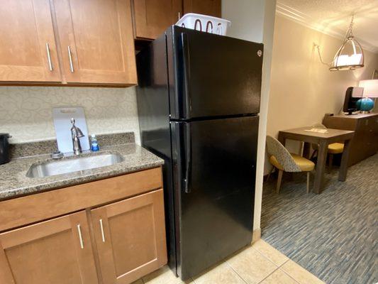 Kitchen with stove , microwave , coffee maker , full size refrigerator , plates , glasses , and utensils