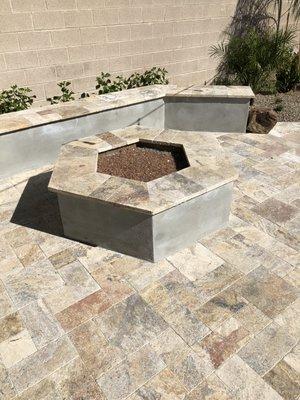 Hexagon shaped bench and firepit with champagne colored glass.  Deck and details are Scabos colored travertine.