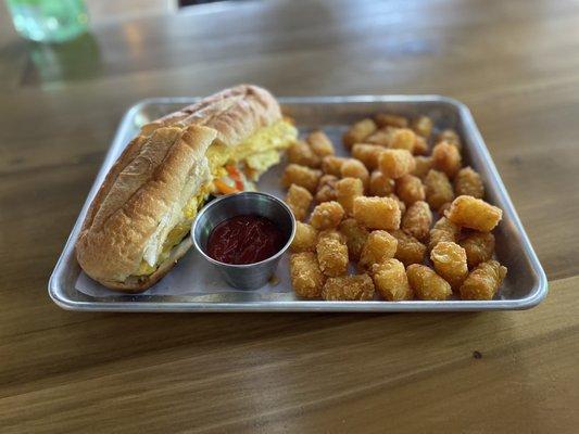 Steak sandwich with eggs and tater tots