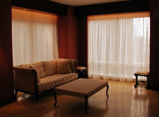 The patterned sheer curtains complement the eclectic style of this room.