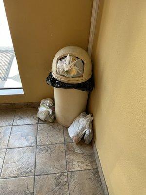 Trash still piled by trash cans when entering hotel