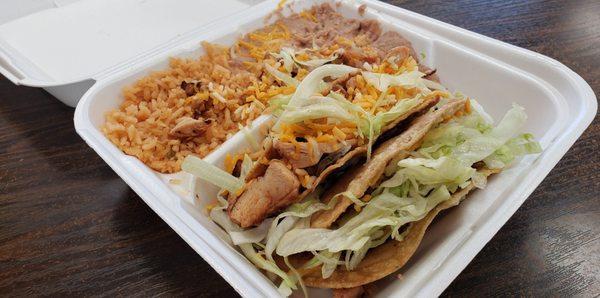 Two tacos (1 beef, 1 chicken) with rice and beans