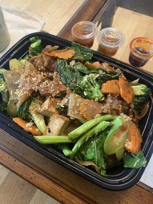 Pad see ew with tofu, spicy sauces in the back