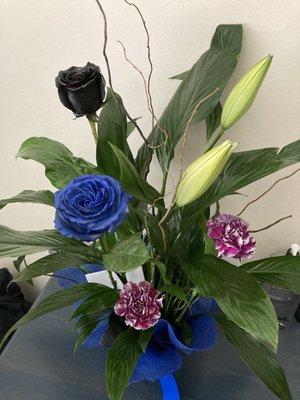 Peace Lily arrangement, blue and black painted roses and some other lovely add-ins