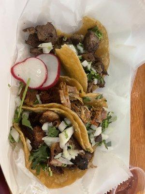 Tripa, carnitas, lengua tacos from bottom to top