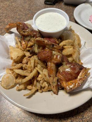 The bacon wrapped shrimp and chicken appetizer on a bed of fried onions served with ranch