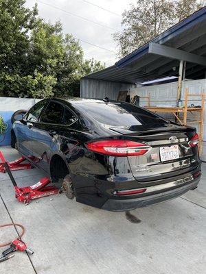 My vehicle on jackstands as they are putting my new tires on my rims.