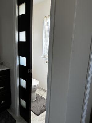 New water closet with pocket door.