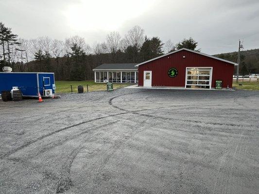 Outside parking with food truck to left. In distance is outdoor covered screened patio, inside seating and bar and brew space