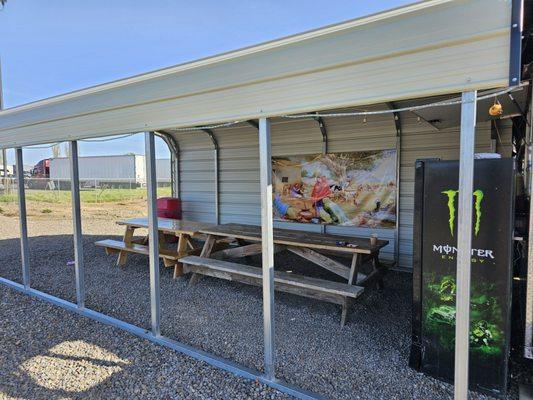 Two large picnic tables with a covered awning.