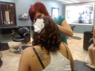 Kristin, one of BellAmore's fine hair stylists, finishing up a customer's flower-accentuated style.