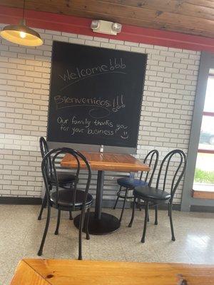 A table with a chalk board near the door.