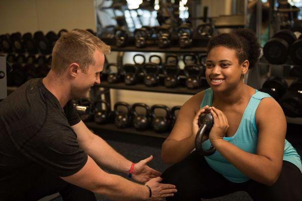 Robbie helping a client correct her squat form.