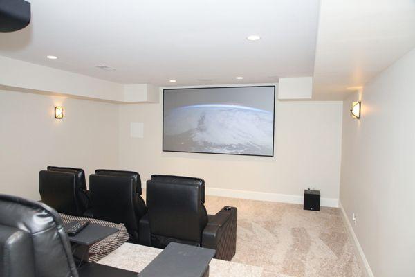 A complete home theater system with motorized seating by Octane Seating featuring 4K projection by Sony.