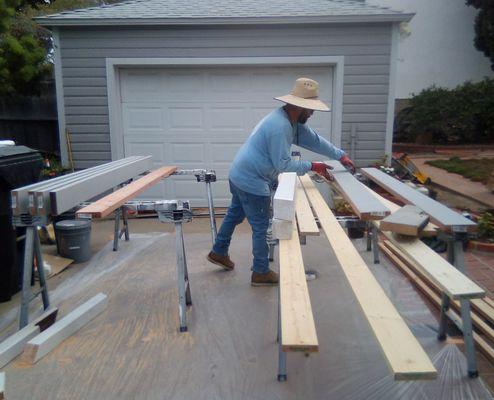 Nefi is organizing the pressure-treated lumber for sawing and painting.