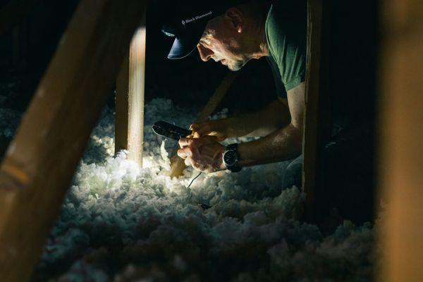 One of our expert attic insulation installers completing blown in attic insulation services.