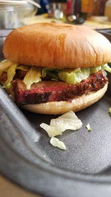 The large brisket sandwich with lettuce, tomato, & BBQ sause.