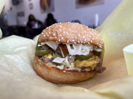 Single Burger with cheese, jalapeños, grilled onions and hot sauce