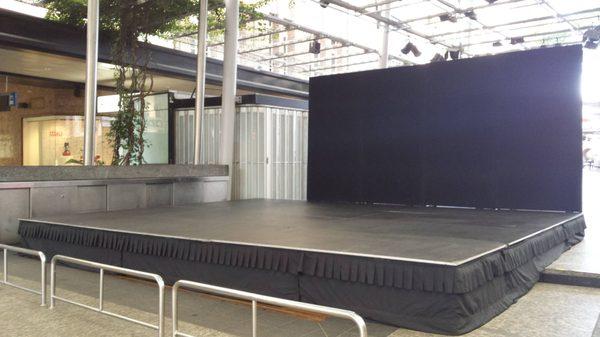 Stage rental with pipe and drape with black drapes.