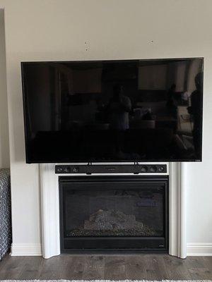 installation of the TV over the fireplace on a retractable mount.