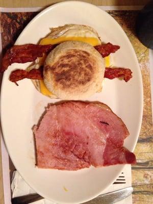 Egg sandwich with bacon and side of ham