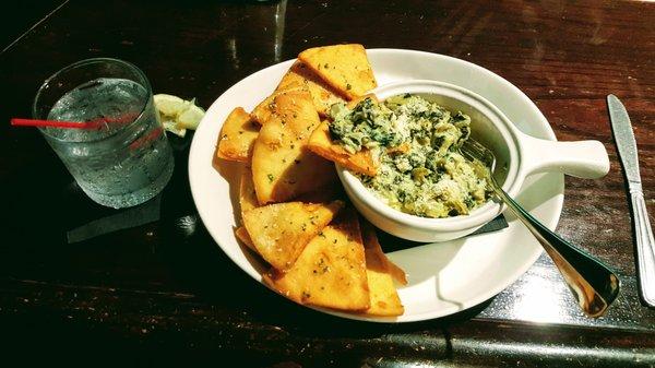 Spinach artichoke dip with toasted, seasoned pita wedges.